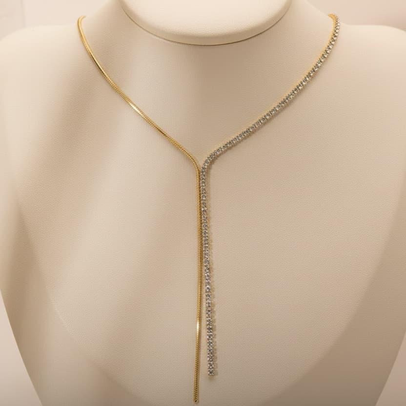 Gold plated tennis snake chain tassel necklace flat lay — affordable luxury jewellery