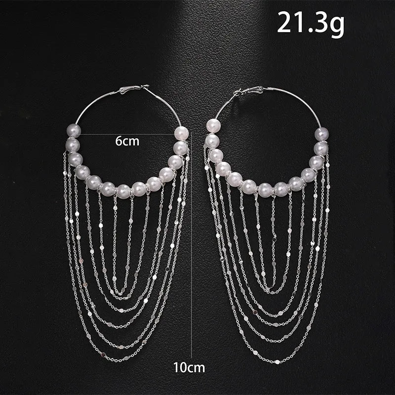 Gold-tone freshwater pearl hoops with graduated chain tassels on white – festive statement earrings for women – Oneofé