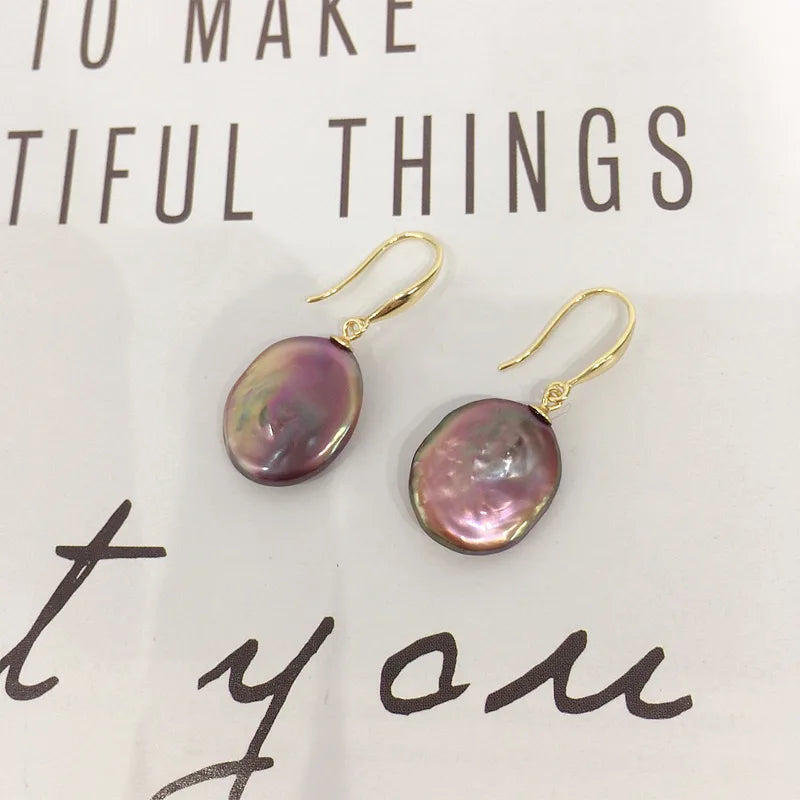 Gold plated copper purple baroque pearl drop earrings on a printed page – everyday jewellery for women – Oneofé