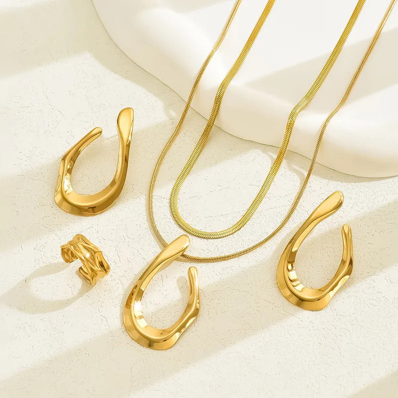 Gold-tone stainless steel teardrop jewellery, chains and textured ring on ivory stone – statement set for women – Oneofé