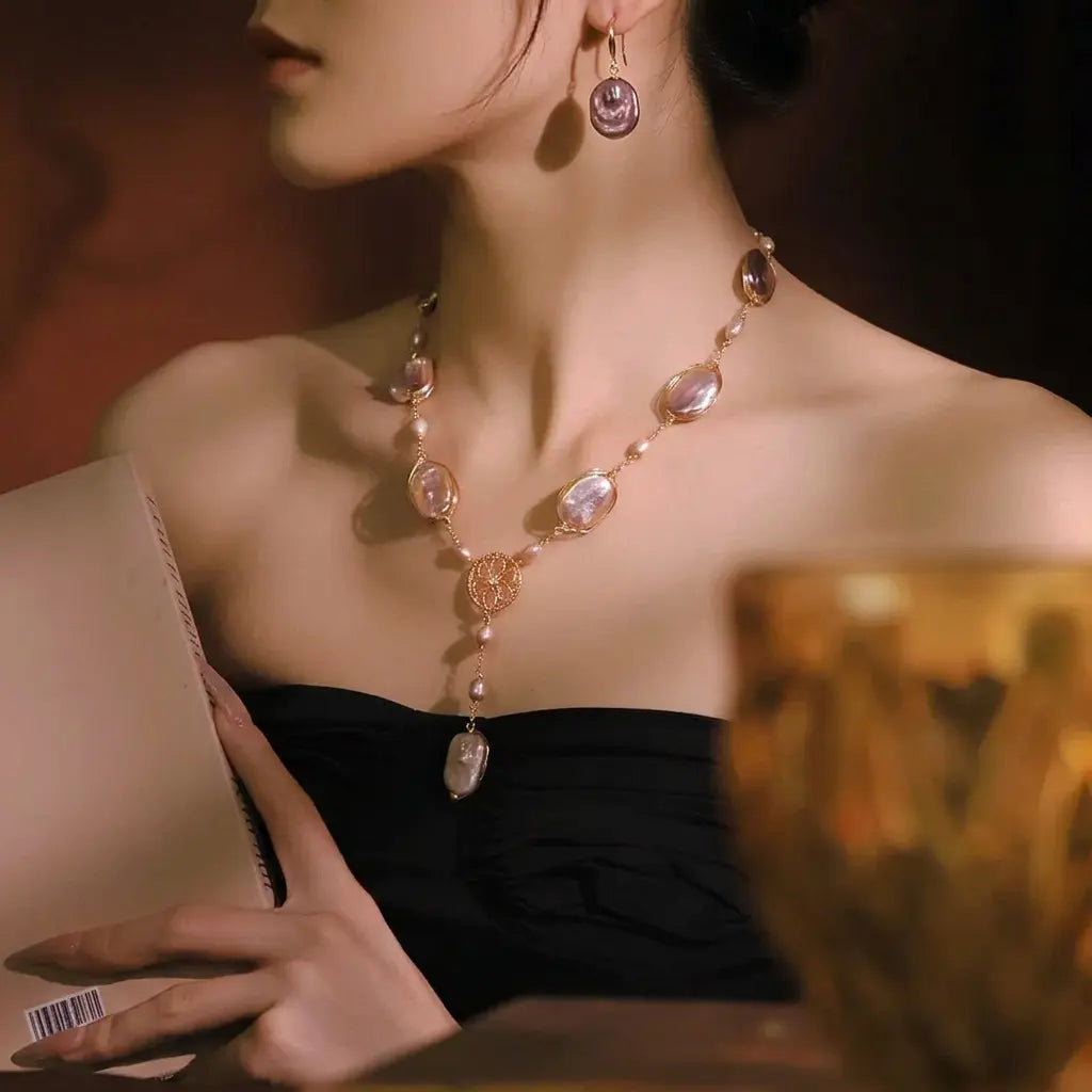 Gold plated copper purple baroque pearl drop earrings on a model with pearl necklace – evening wear for women – Oneofé