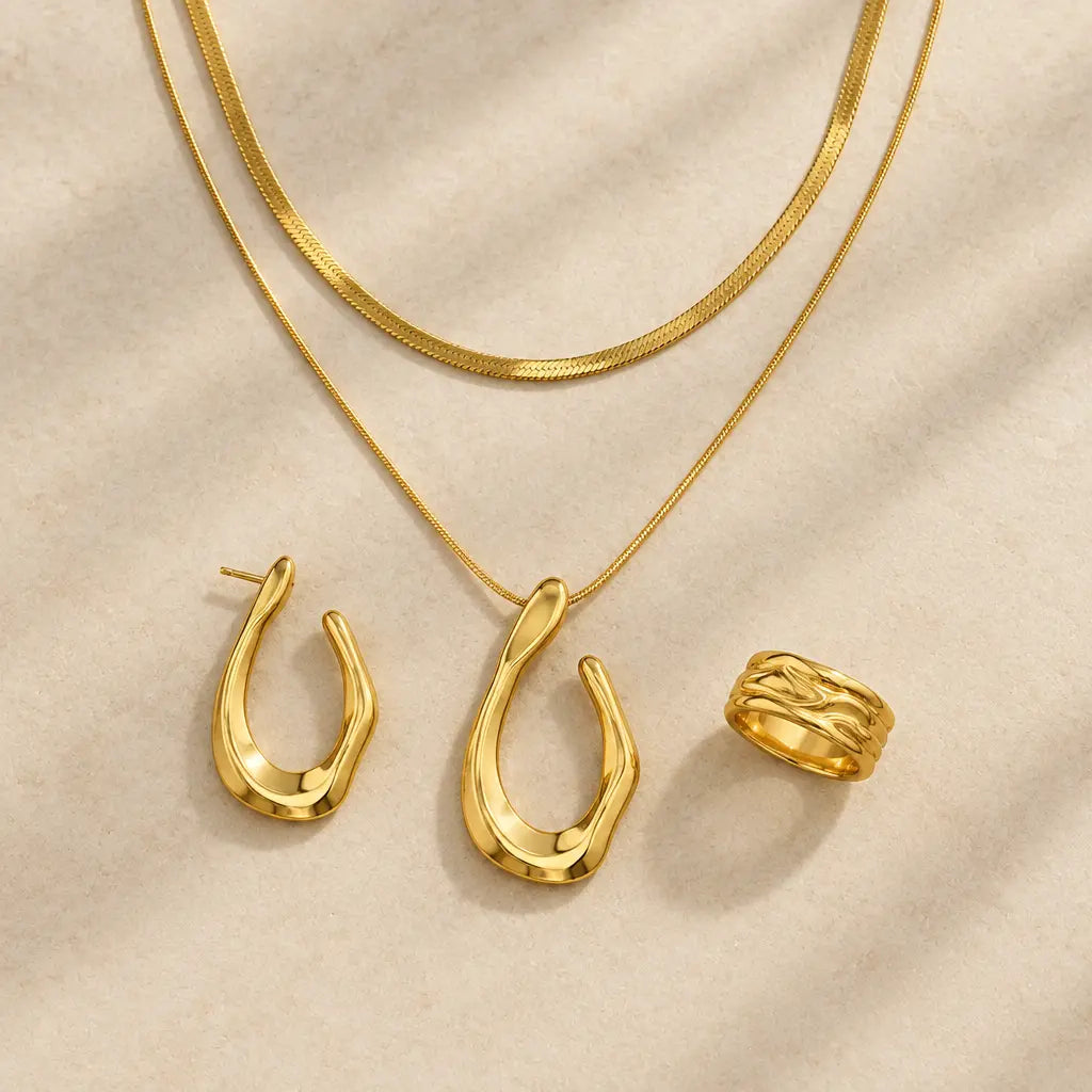 Gold-tone stainless steel teardrop jewellery, chains and textured ring on ivory stone – statement set for women – Oneof