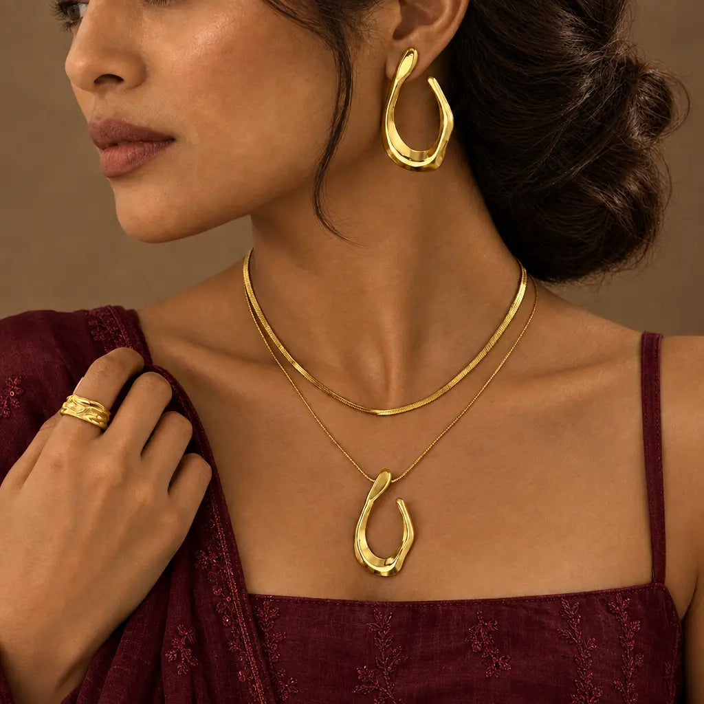 Gold-tone stainless steel teardrop jewellery with a burgundy spaghetti-strap kurta – festive wear for women – Oneofé