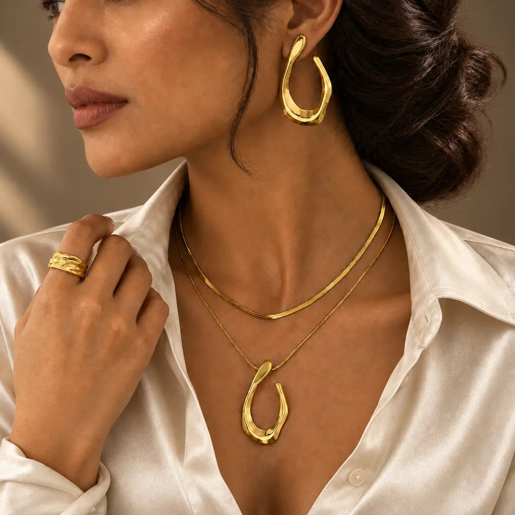 Gold-tone stainless steel teardrop jewellery with an ivory satin blouse – everyday styling for women – Oneofé